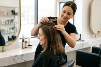 Pose d'extensions à clip dans un salon de coiffure professionnel sur cheveux bruns naturels